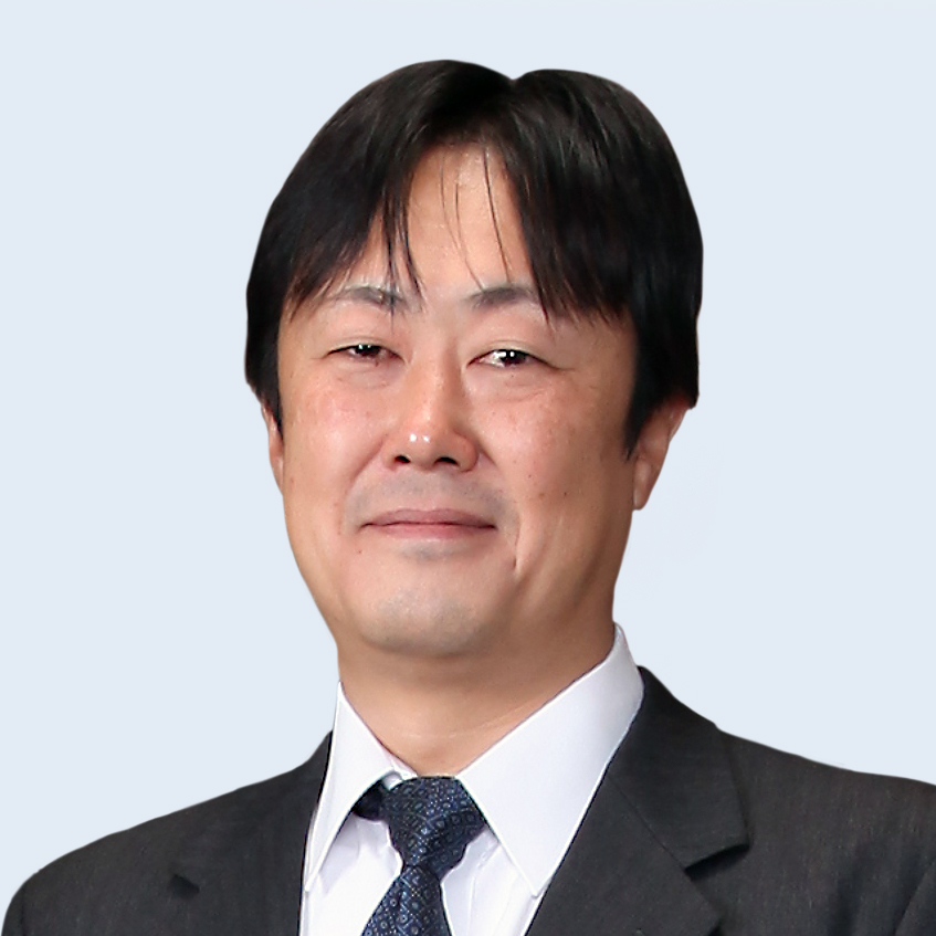 A headshot of Atsushi Tsukamoto in suit